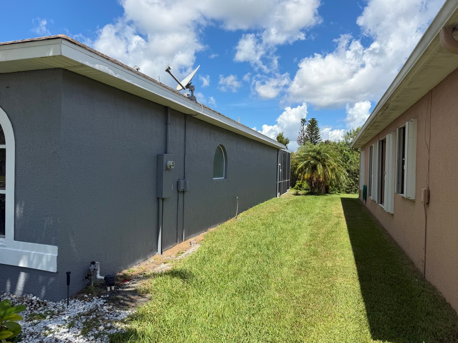 Side stucco wall after crack repair and exterior painting on a Viera Suntree FL home