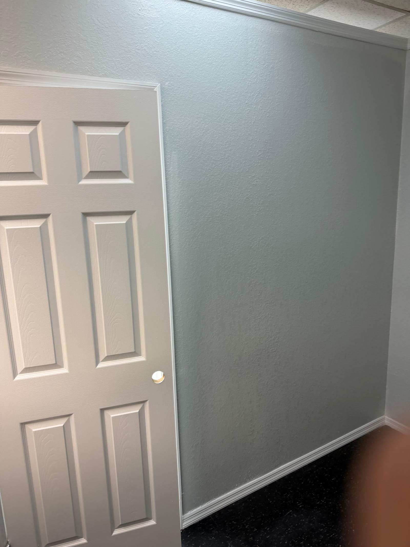 Finished painted wall, trim, and door in the new Exodus Barbershop stylist room