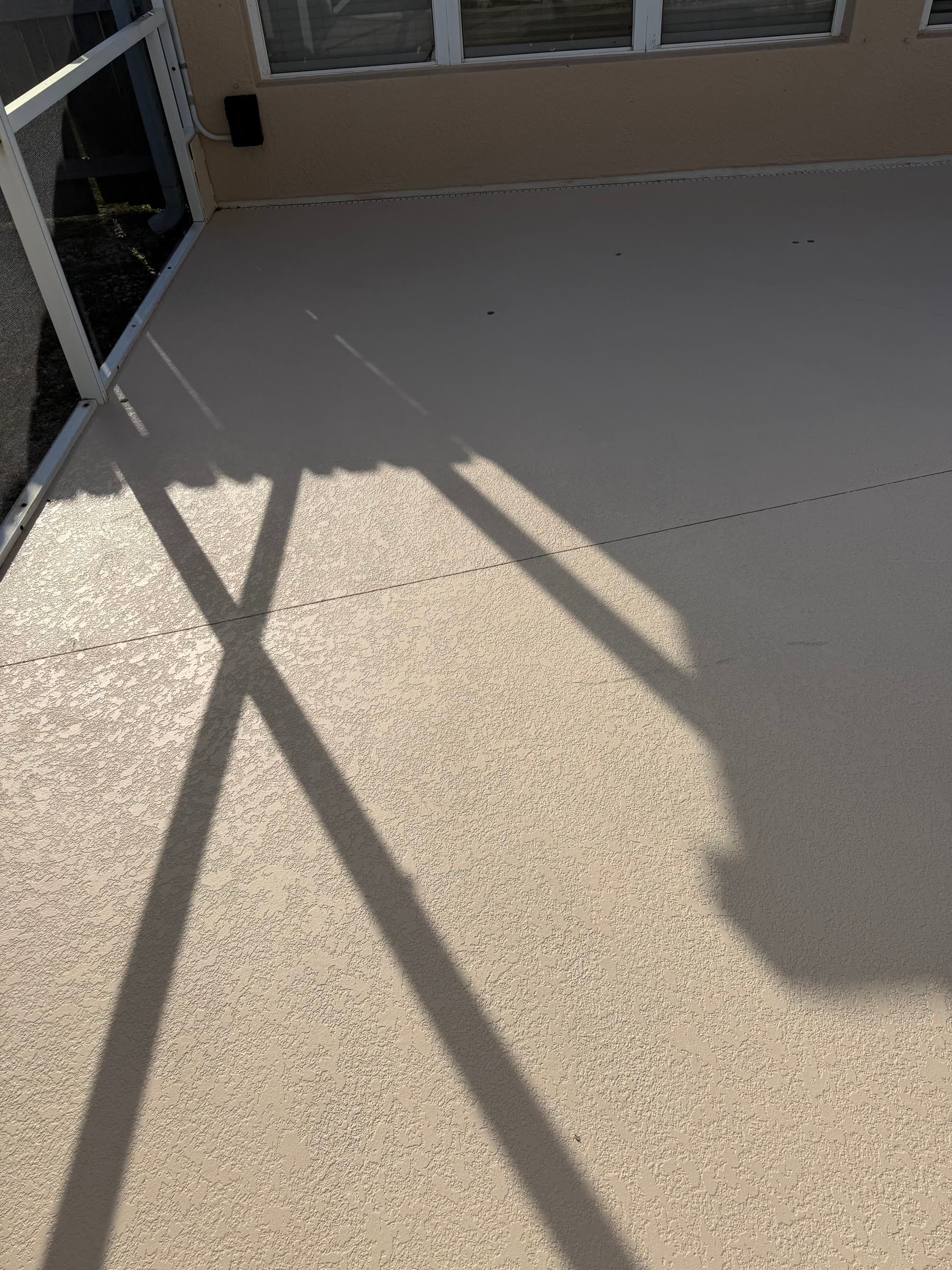 Finished pool deck beside the house after exterior maintenance in Palm Bay FL