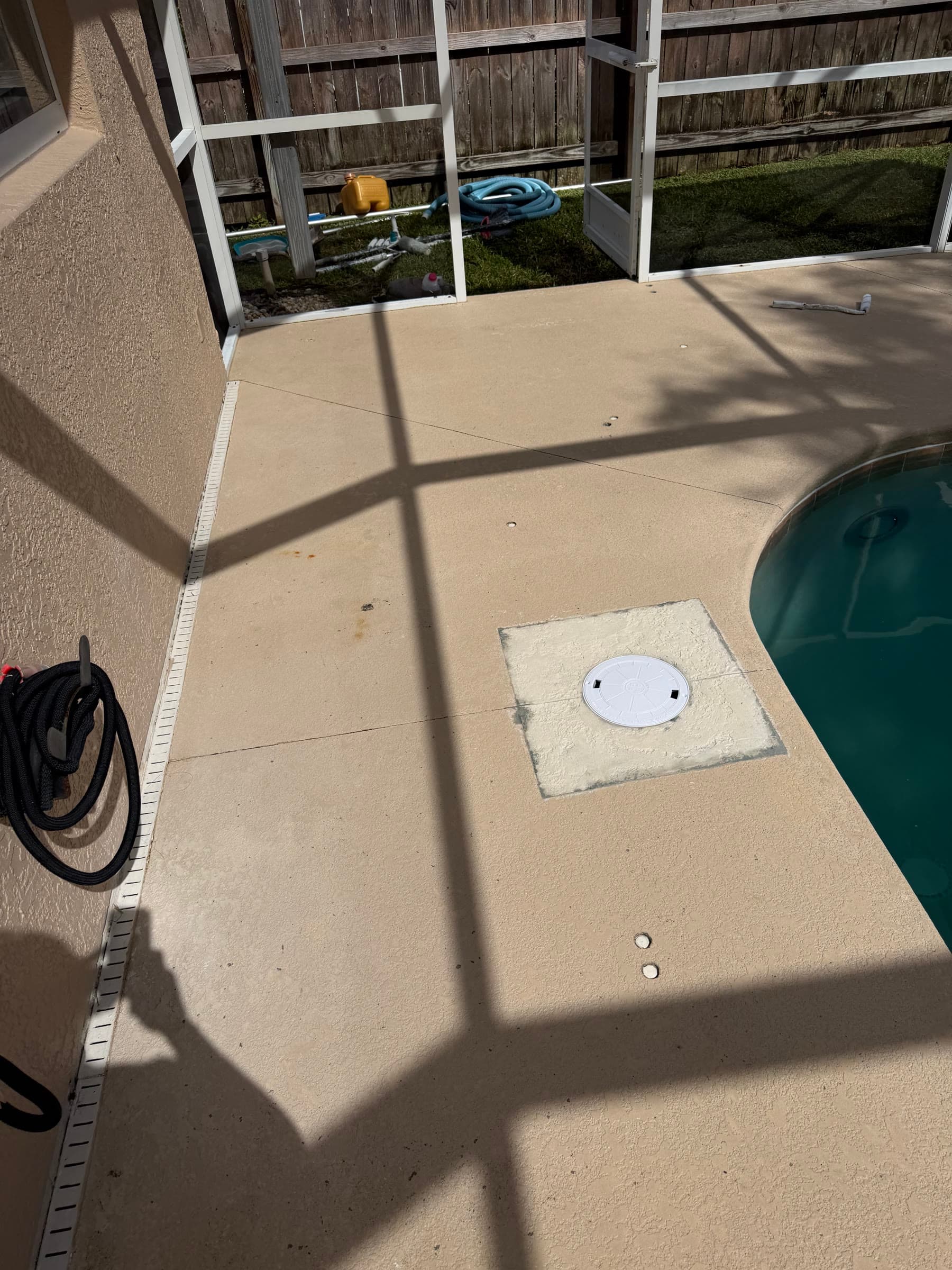 Pool-edge deck surface and access cover before preparation in Palm Bay FL